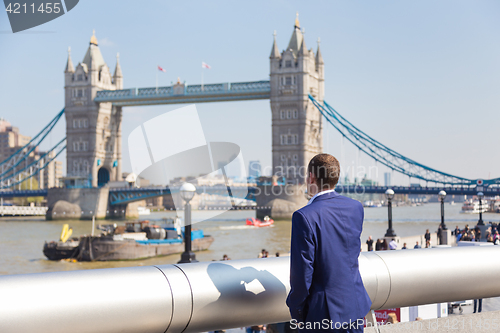 Image of British businessman talking on mobile phone outdoor in London city, UK.