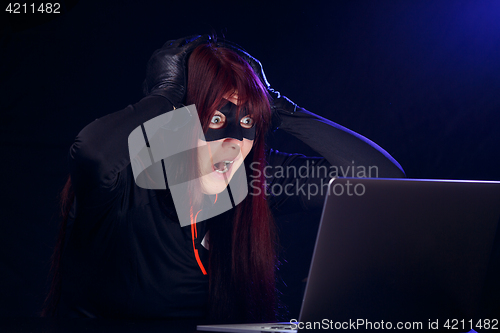 Image of Surprised hacker next to laptop