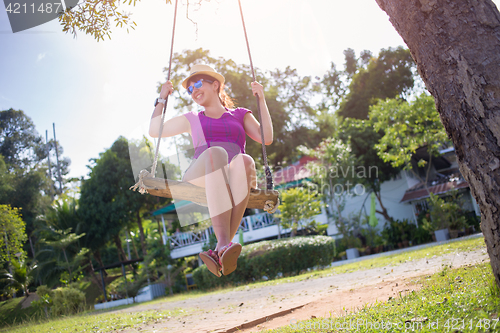 Image of Brunette on swing at beach