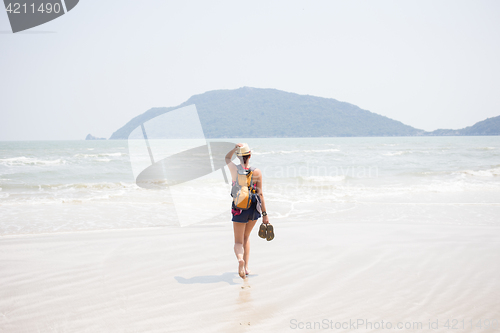 Image of Girl with sandals in hands