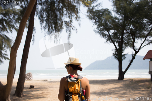 Image of Brunette in hat stands back