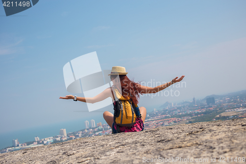 Image of Brunette sits back on hill