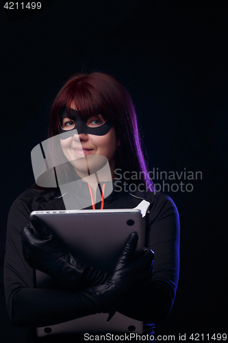 Image of Brunette thief holds stolen laptop