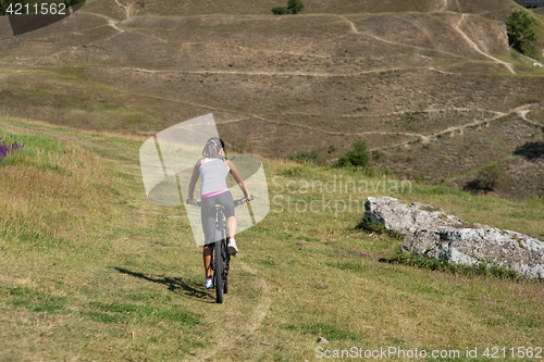 Image of Mountain biking happy sportive girl relax in meadows sunny countryside