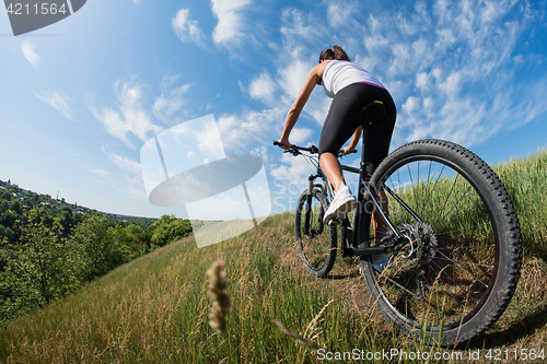 Image of Sport bike woman on the meadow with a beautiful landscape