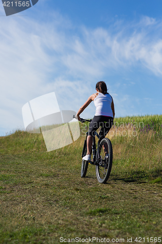 Image of Sport bike woman on the meadow with a beautiful landscape