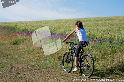 Image of Sport bike woman on the meadow with a beautiful landscape