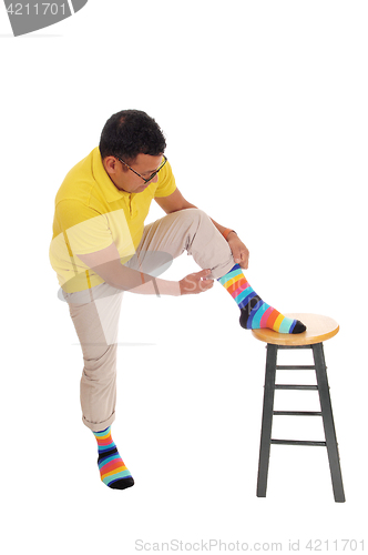 Image of Man putting on his colorful socks.