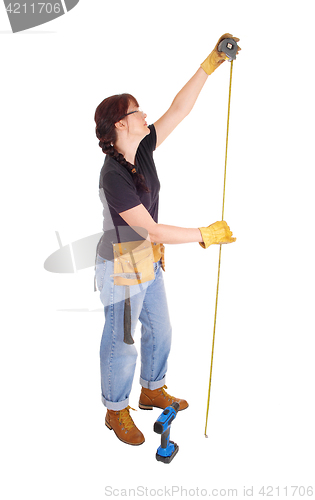 Image of A handy woman measuring for work.