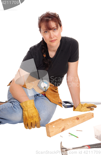 Image of Woman sitting and working with tools.