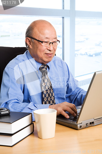 Image of Working senior asian businessman