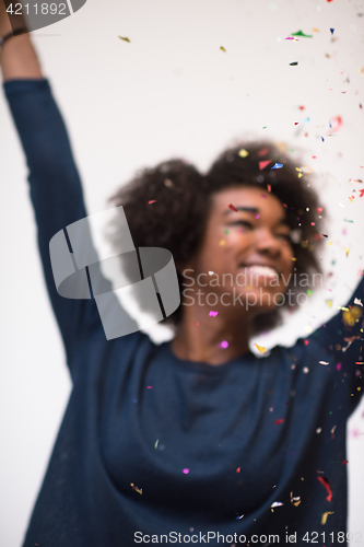 Image of African American woman blowing confetti in the air