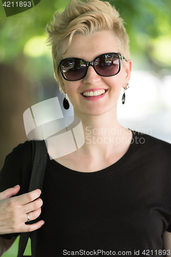 Image of young woman with short blond hair and sunglasses