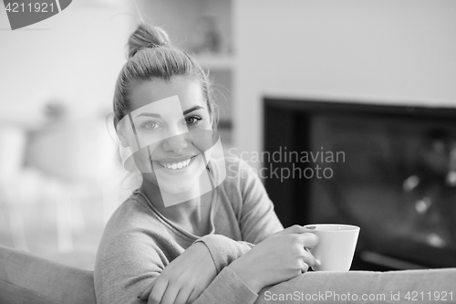 Image of woman with a mug near a fireplace