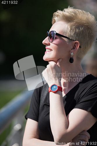 Image of young woman with short blond hair and sunglasses