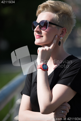 Image of young woman with short blond hair and sunglasses