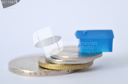 Image of Little plastic house on metal coins