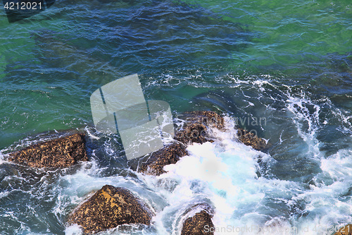 Image of Marine wave breaks against offshore stone