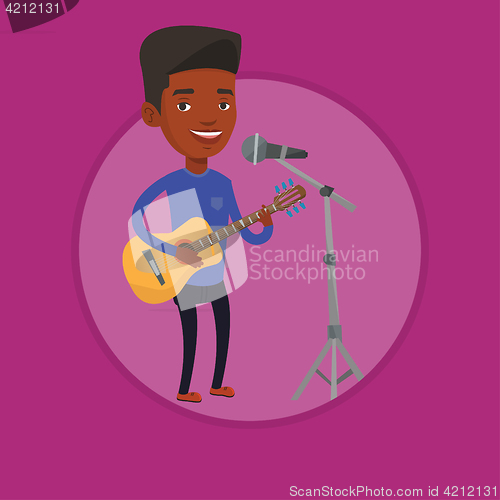 Image of Man singing in microphone and playing guitar.