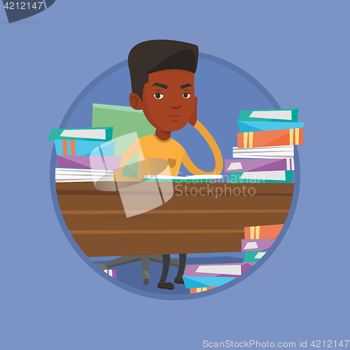 Image of Student sitting at the table with piles of books.