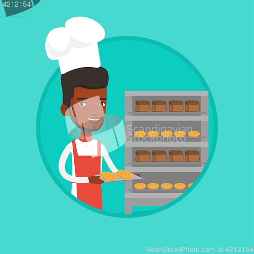 Image of Happy young male baker holding tray of bread.