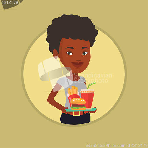 Image of Woman holding tray full of fast food.