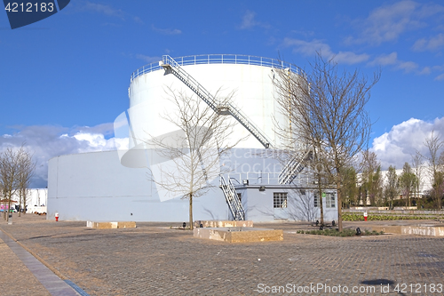 Image of White tanks in tank farm with iron staircase 