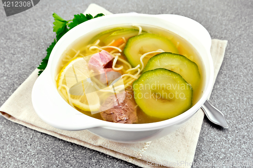 Image of Soup with zucchini and noodles on stone table