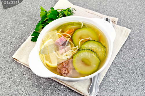 Image of Soup with zucchini and noodles on granite table