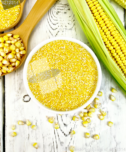 Image of Corn grits in bowl with cobs on board top