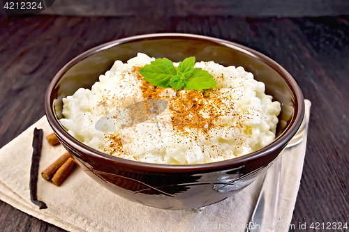 Image of Rice porridge with cinnamon in bowl on napkin