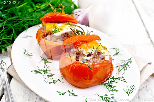 Image of Tomatoes stuffed with meat and rice with dill in plate on board