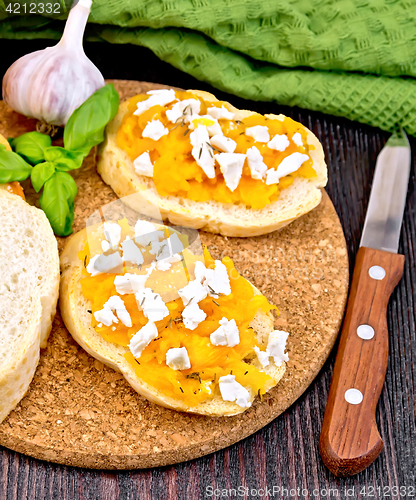 Image of Bruschetta with pumpkin and cheese on dark board