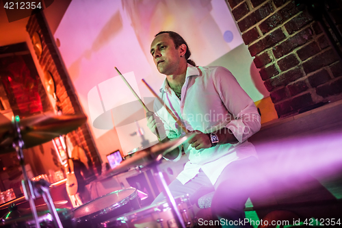 Image of Drummer playing on drum set on stage.