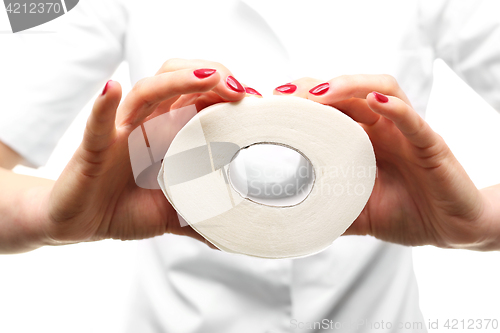 Image of Hands beauticians squeeze roll of toilet paper .