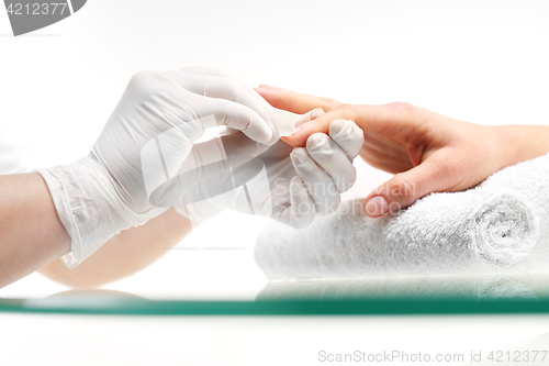 Image of Nail polish remover, manicure Removal of nail varnish. manicure Beautician removes nail polish with a cotton ball soaked in acetone.