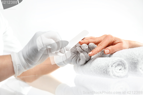 Image of Sawing nails, manicure . Treatment hand and nail care, the woman to a beautician for a manicure.