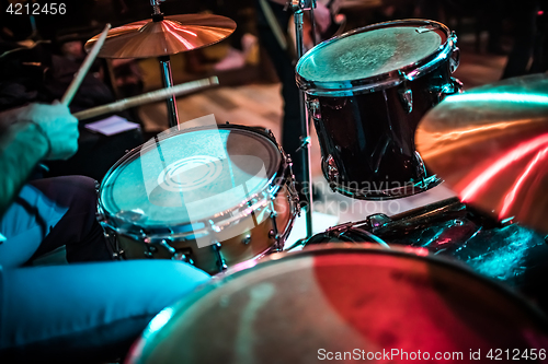 Image of Drummer playing on drum set on stage.