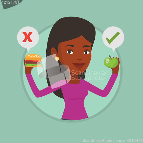 Image of Woman choosing between hamburger and cupcake.