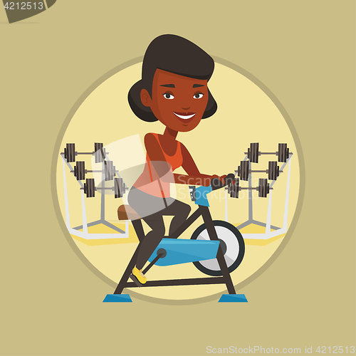 Image of Young woman riding stationary bicycle.