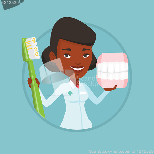 Image of Dentist with dental jaw model and toothbrush.