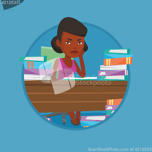 Image of Student sitting at the table with piles of books.