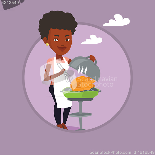 Image of Woman cooking chicken on barbecue grill.