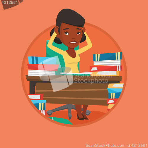 Image of Student sitting at the table with piles of books.