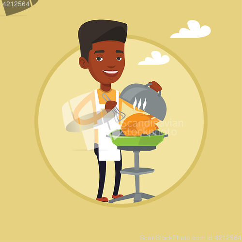 Image of Man cooking chicken on barbecue grill.