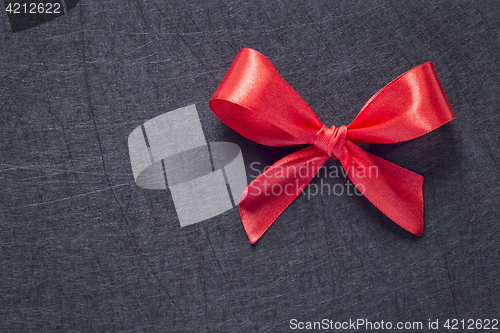 Image of Red bow on black textured background