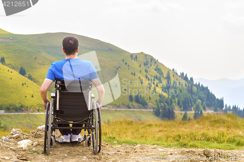 Image of Young man in a wheelchair enjoying fresh air on a sunny day