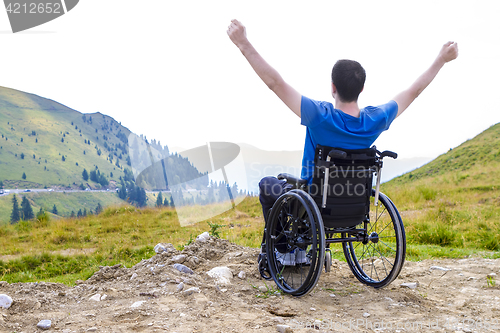 Image of optimistic handicapped man sitting on wheelchair