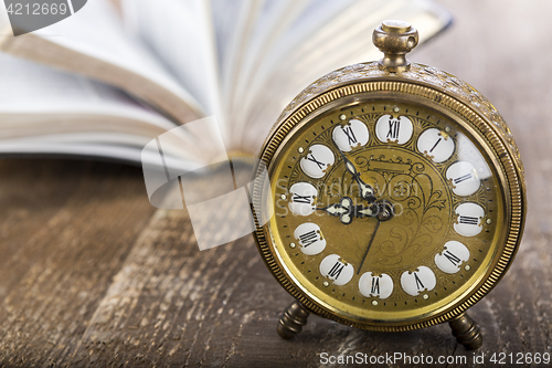 Image of Holy Bible and alarm clock on wood table