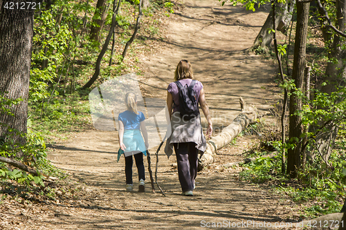Image of Mother and daughter walking in spring forest